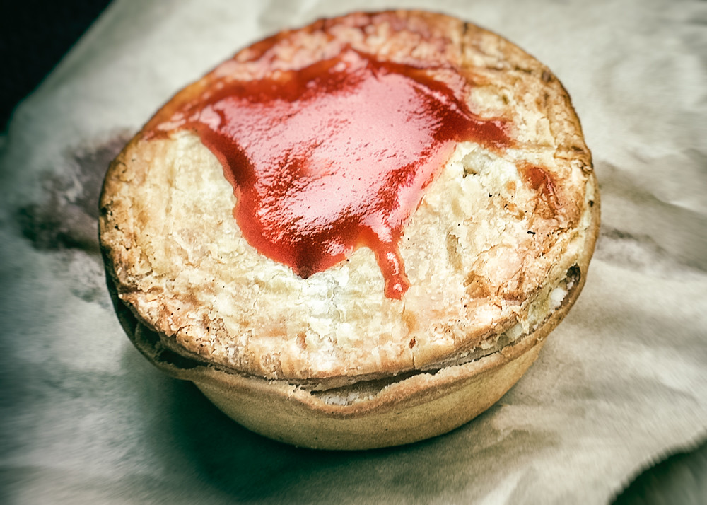 Meat pie australienne ouverte, garnie de bœuf en sauce, avec du ketchup
