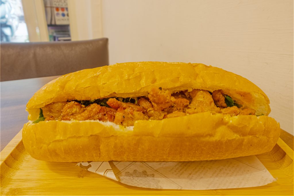 Banh mi vietnamien garni de porc grillé, de légumes marinés et de coriandre