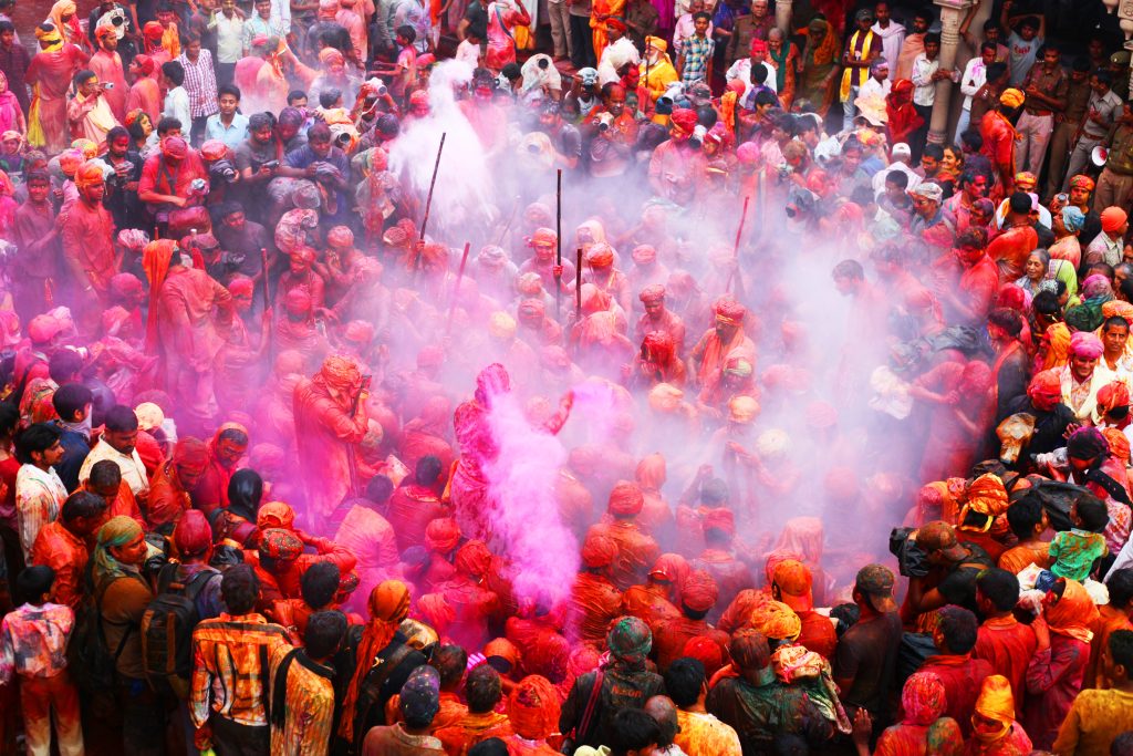 Foule couverte de poudres colorees pendant le festival Holi a Barsana en Inde