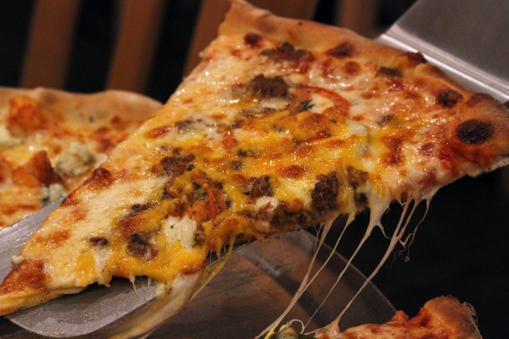 Part de pizza new-yorkaise servie au comptoir