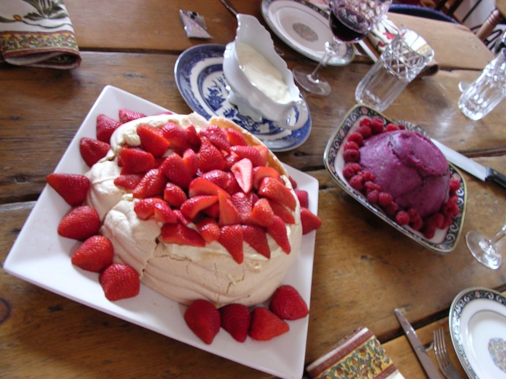Pavlova recouverte de crème fouettée et de fruits frais