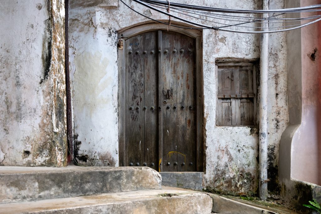 Porte sculptee et facade ancienne dans les ruelles de Stone Town a Zanzibar