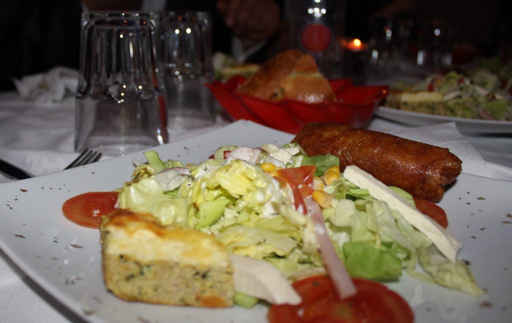 Brik tunisienne dorée servie avec un tajine et une salade